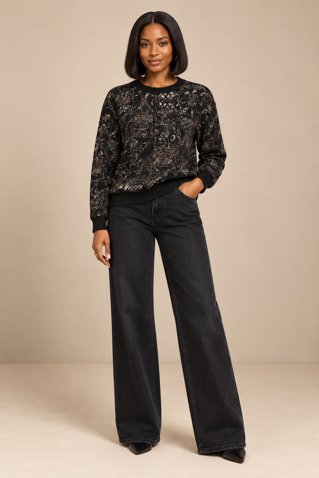 Model wearing Yelé Festivity jacquard crewneck sweater with black wide-leg jeans and pointed shoes
