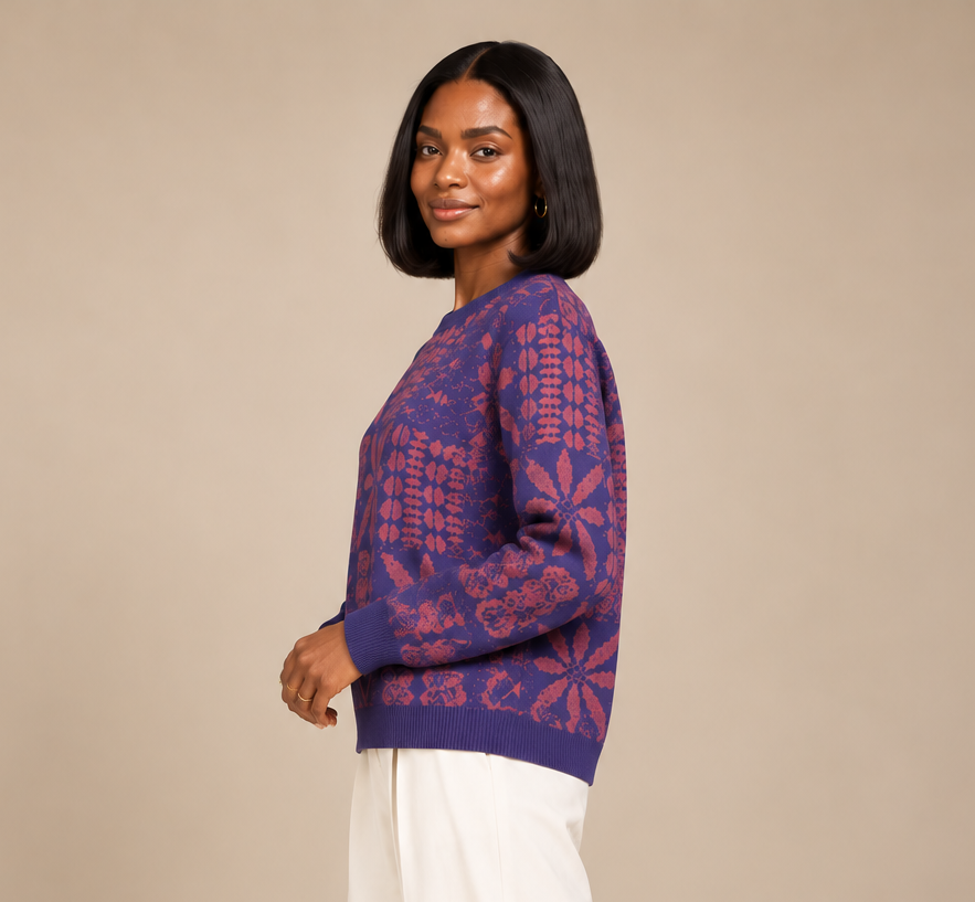 side view of model wearing Yelé Arewa jacquard sweater with full-length sleeves and cream wide-leg trousers