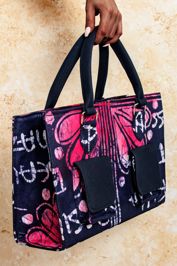 Embrace the vibrant colors and patterns of Africa with our Adire Tote Bag, available in purple and pink variations. Featuring a short handle, two front camo-style pockets, and a spacious interior, this fashionable tote is both functional and stylish.