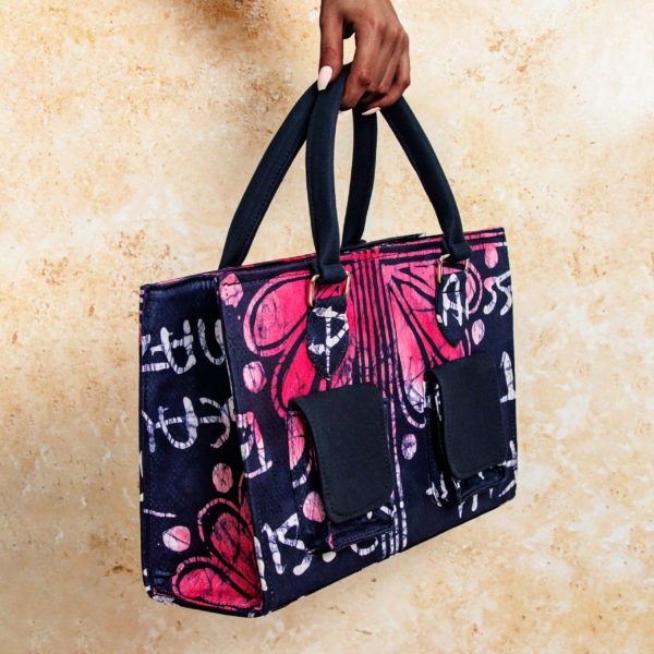 Embrace the vibrant colors and patterns of Africa with our Adire Tote Bag, available in purple and pink variations. Featuring a short handle, two front camo-style pockets, and a spacious interior, this fashionable tote is both functional and stylish.