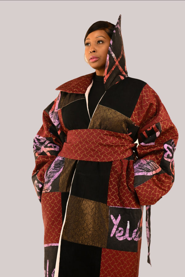 Elegant woman in Yele's Adire and velvet suede kimono dress with a wide fan collar and rich cultural motifs