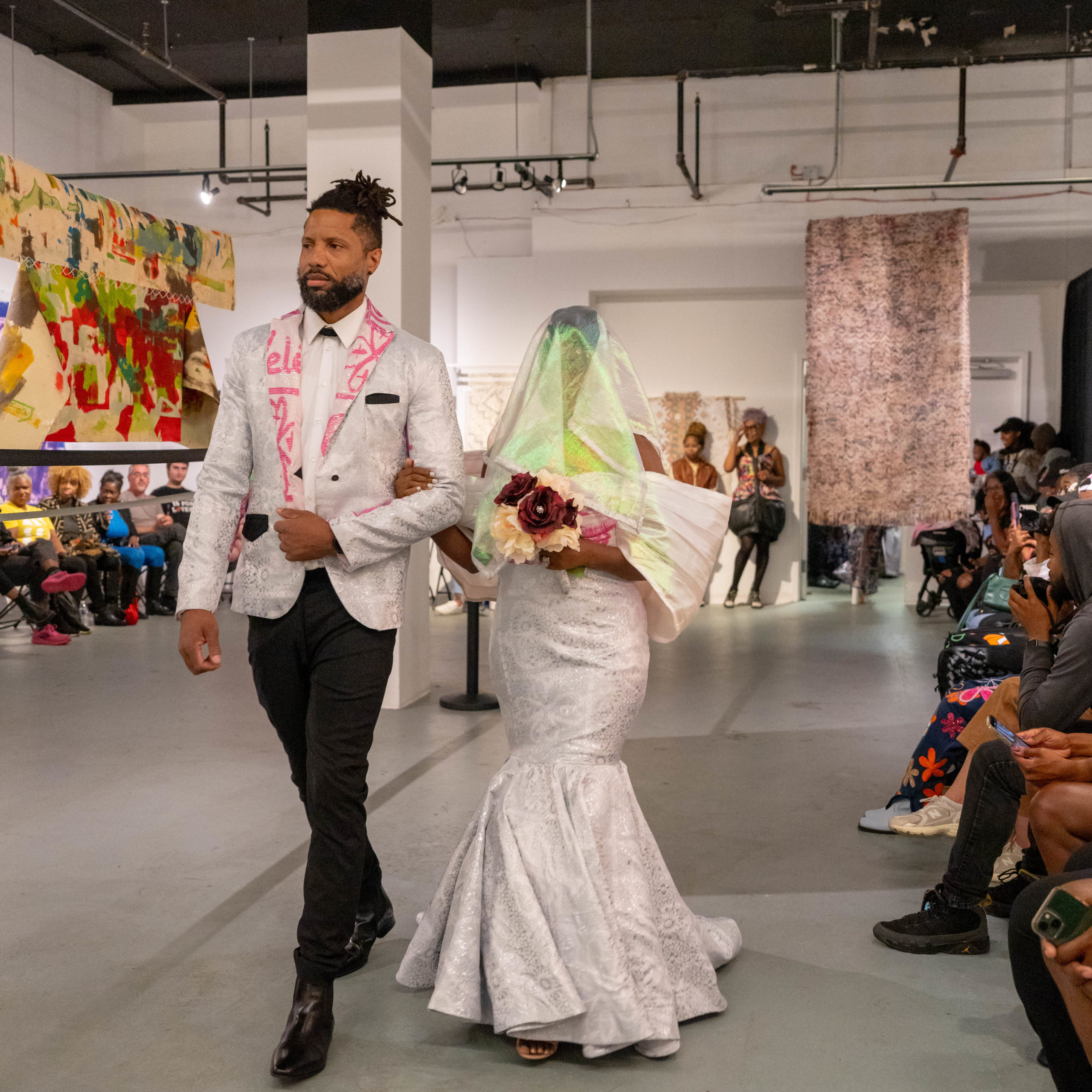African Bride and groom wearing Adinkra prints down an aisle on a fashion runway